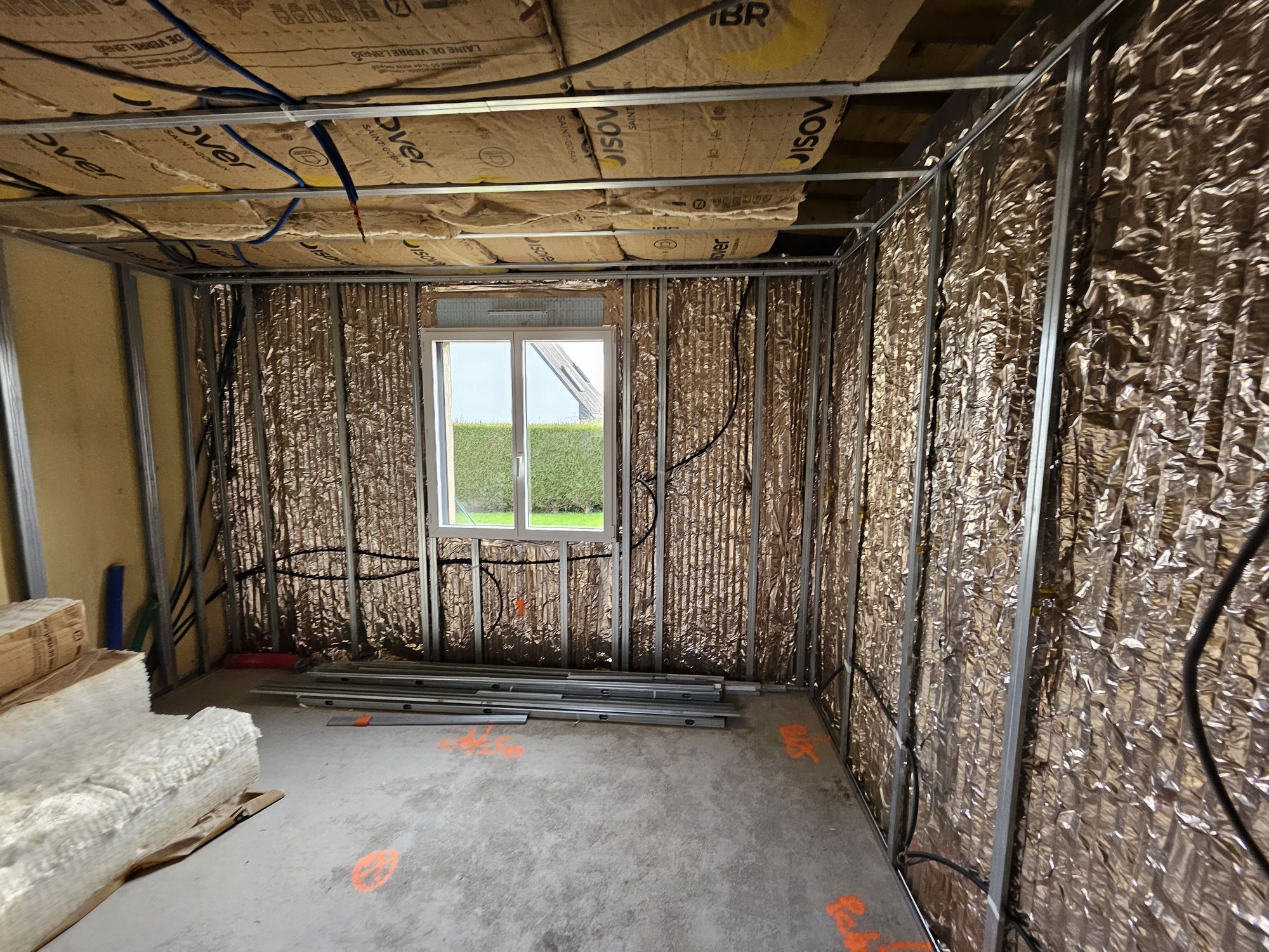 Pose de l’isolation thermique avec laine et panneaux réfléchissants sur les murs et plafond