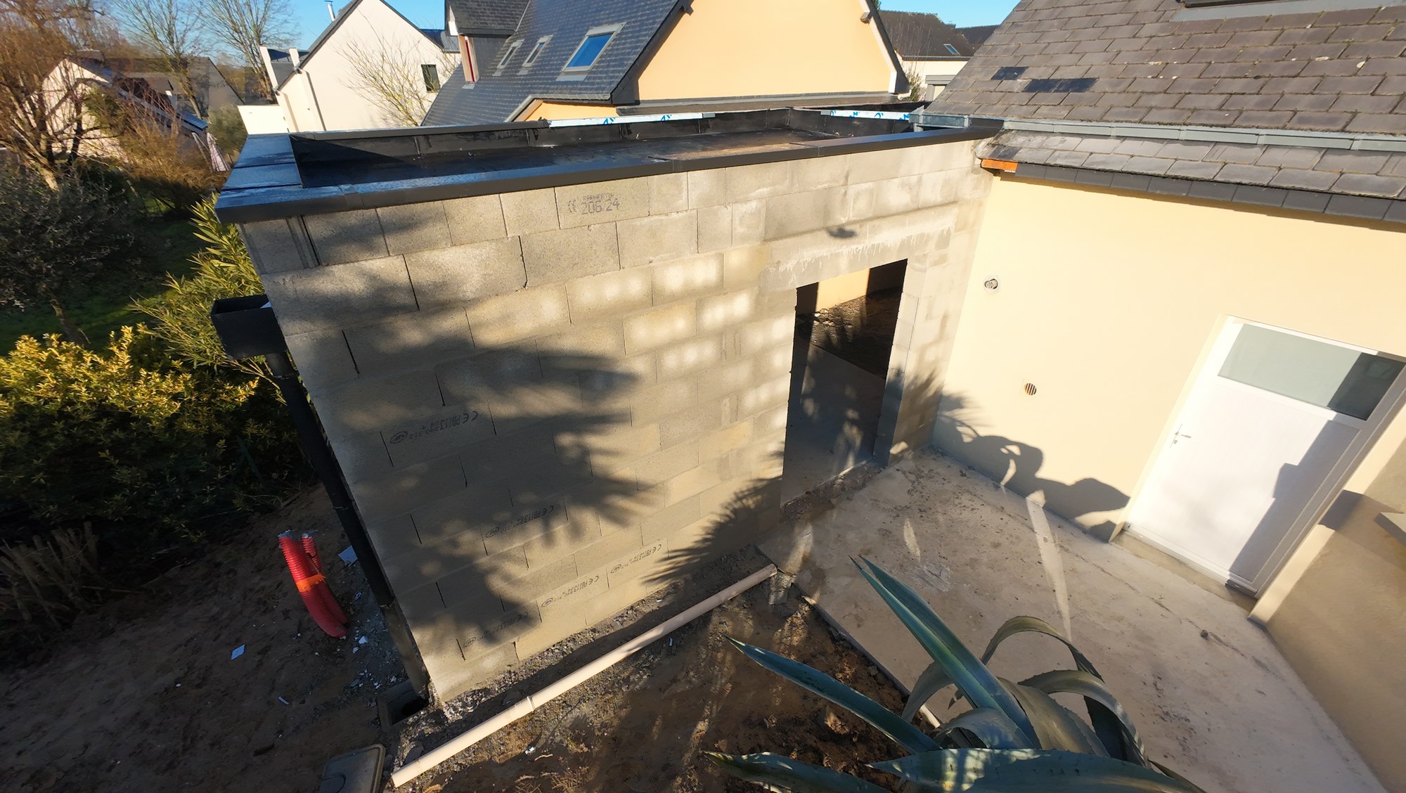  Élévation des murs en parpaings pour la construction d’un garage attenant avec toiture-terrasse